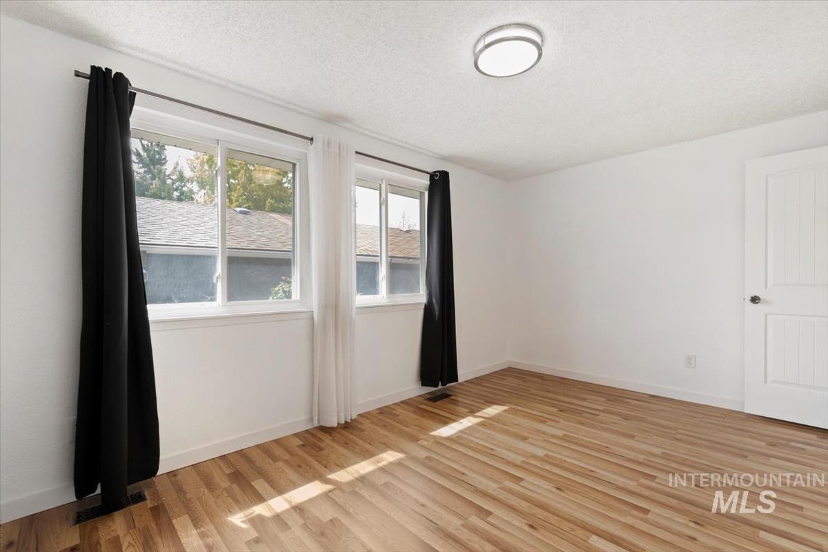 Spare room featuring light wood-style flooring and a textured ceiling