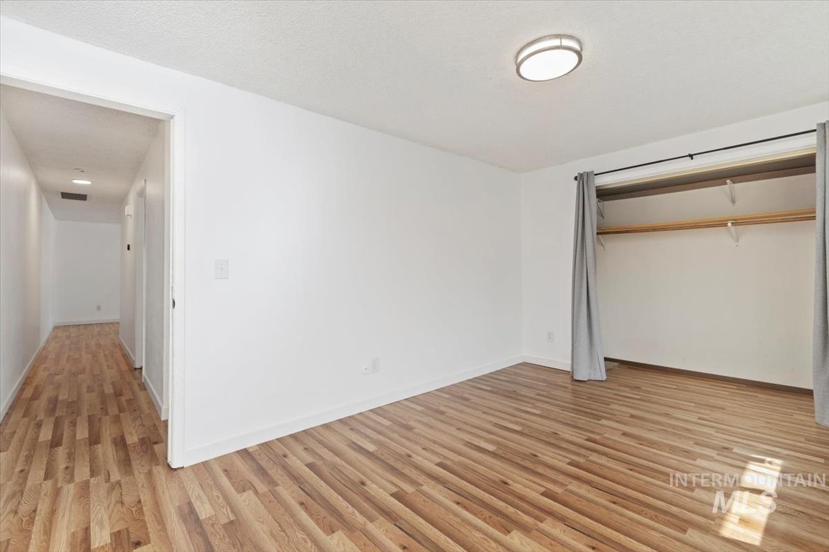 Unfurnished bedroom featuring light wood-style flooring and a closet