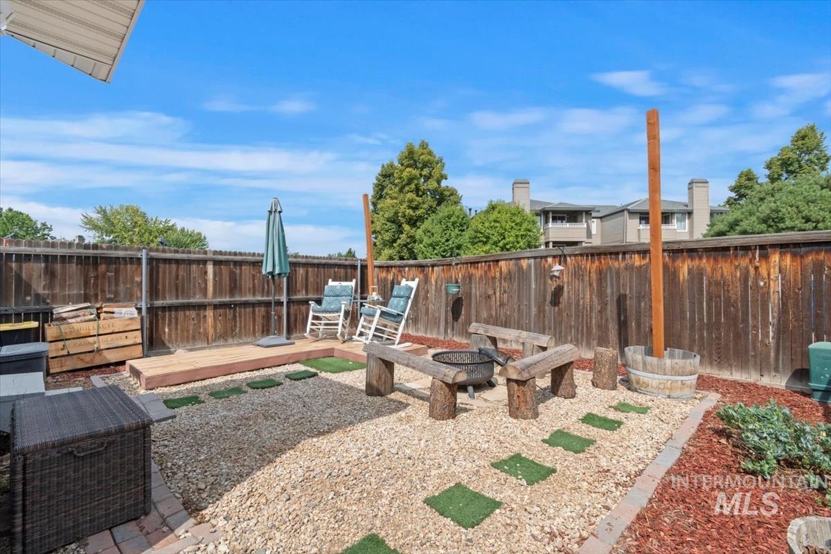 Fenced backyard featuring a deck and an outdoor fire pit