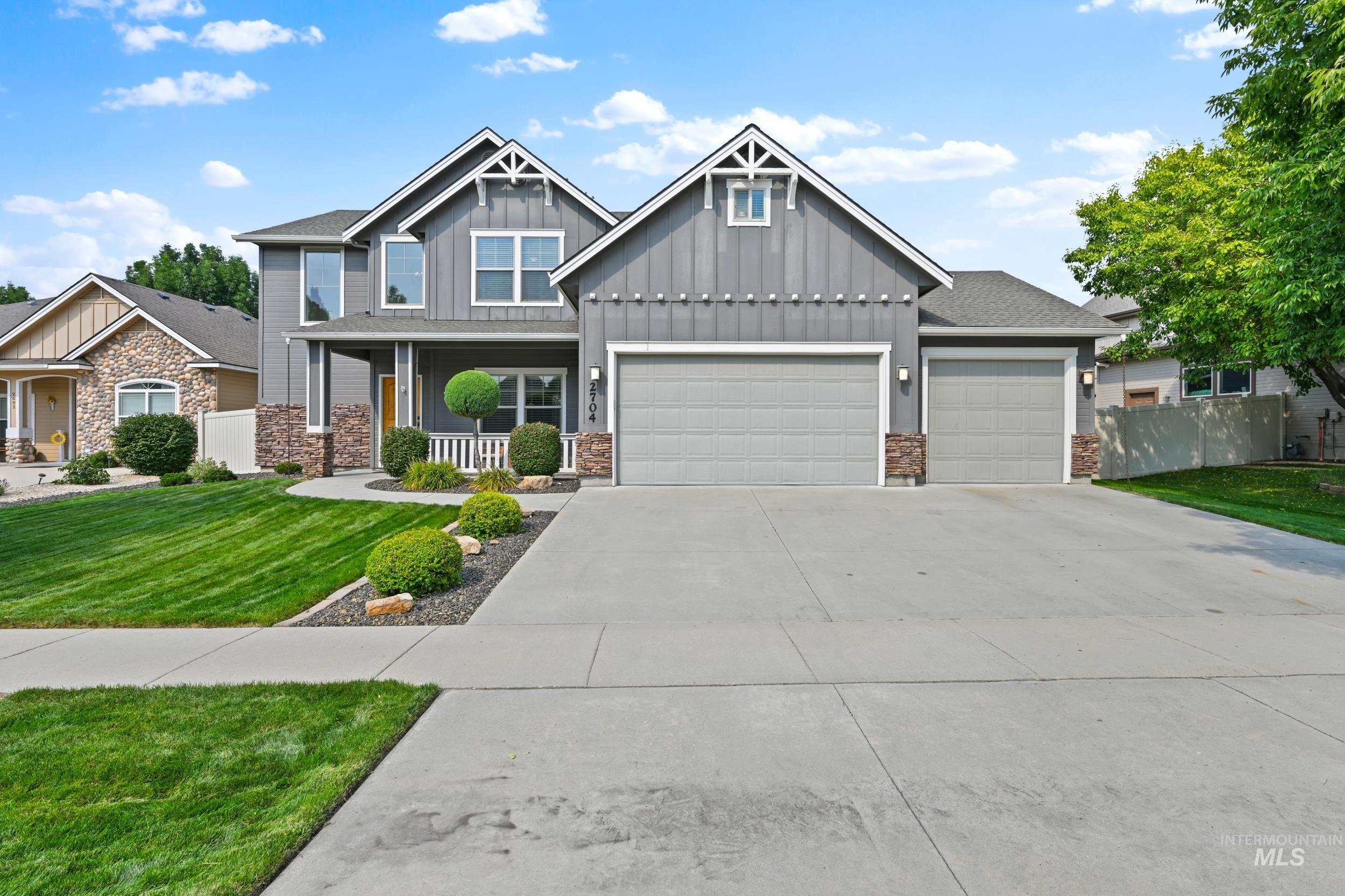 Craftsman house featuring board and batten siding, a porch, concrete driveway, a garage, and stone siding