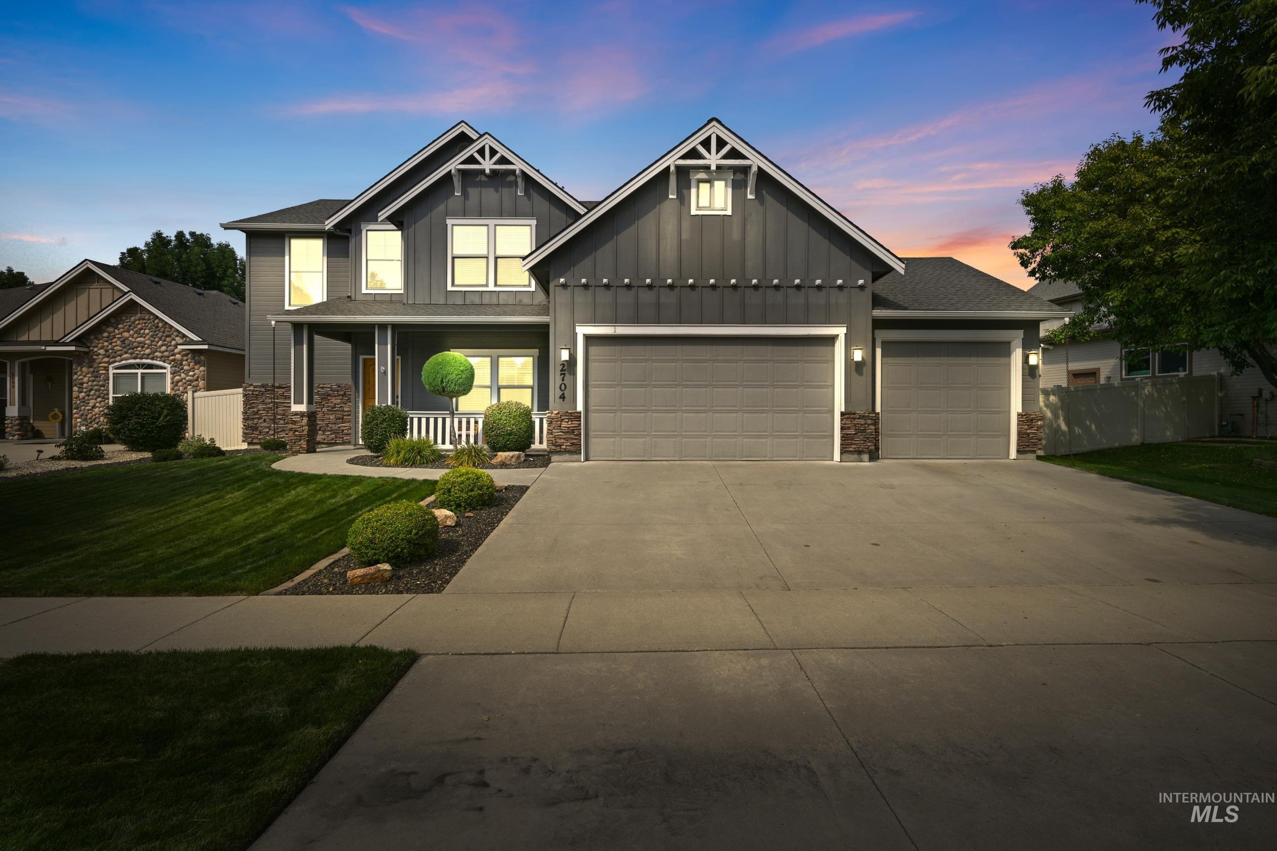 Craftsman inspired home featuring board and batten siding, driveway, a porch, and a garage