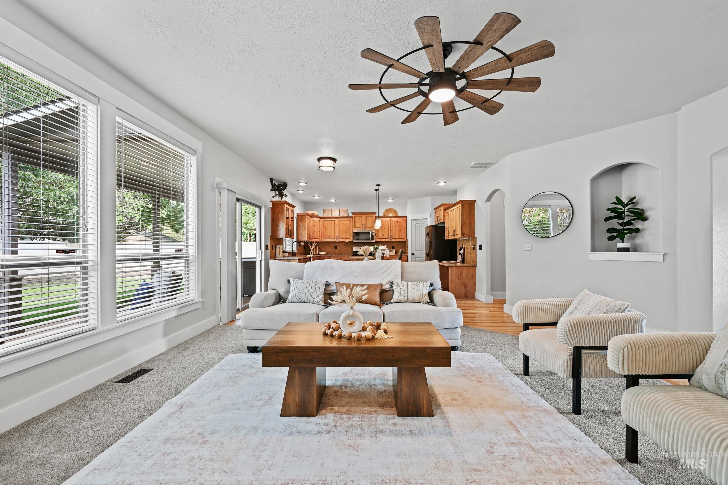 Living room with arched walkways and a ceiling fan
