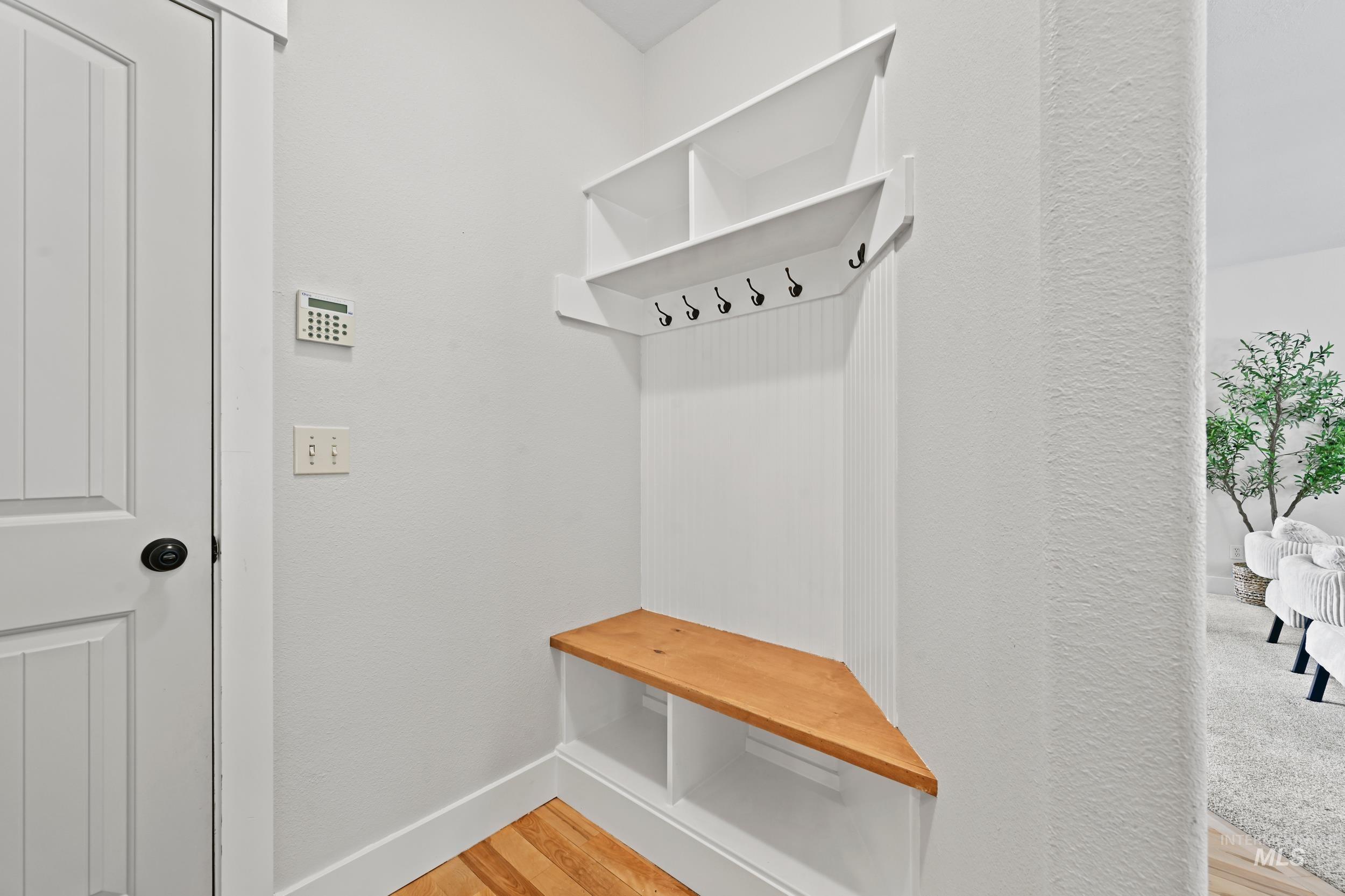 Mudroom featuring light wood finished floors and baseboards