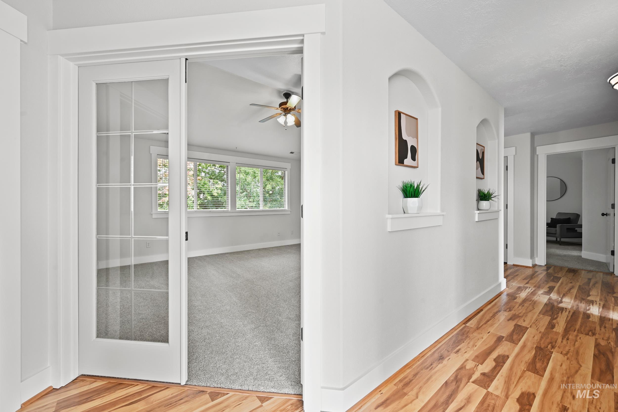 Hallway with light wood-style flooring and baseboards