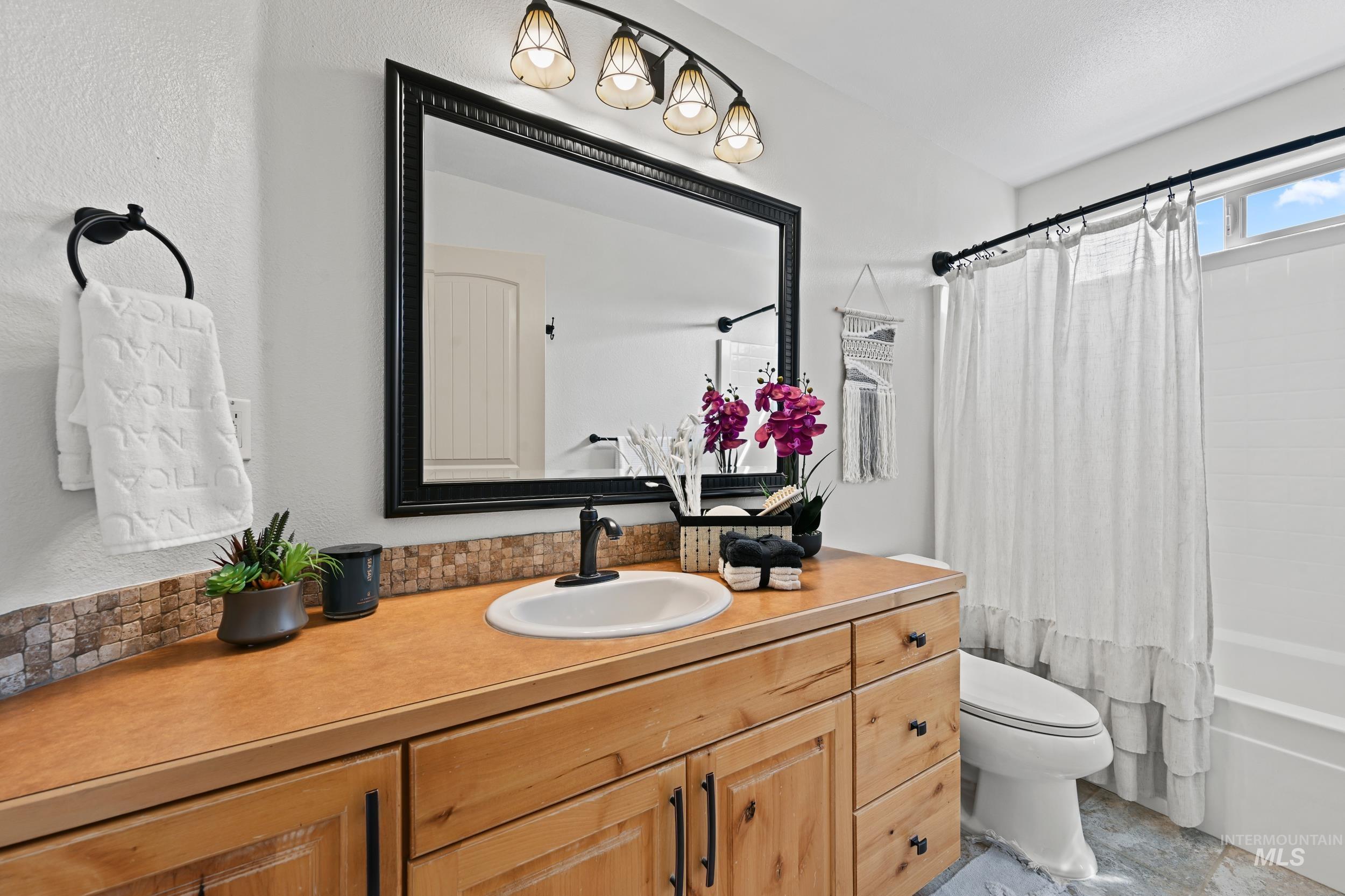 Full bathroom with shower / bath combo with shower curtain and vanity