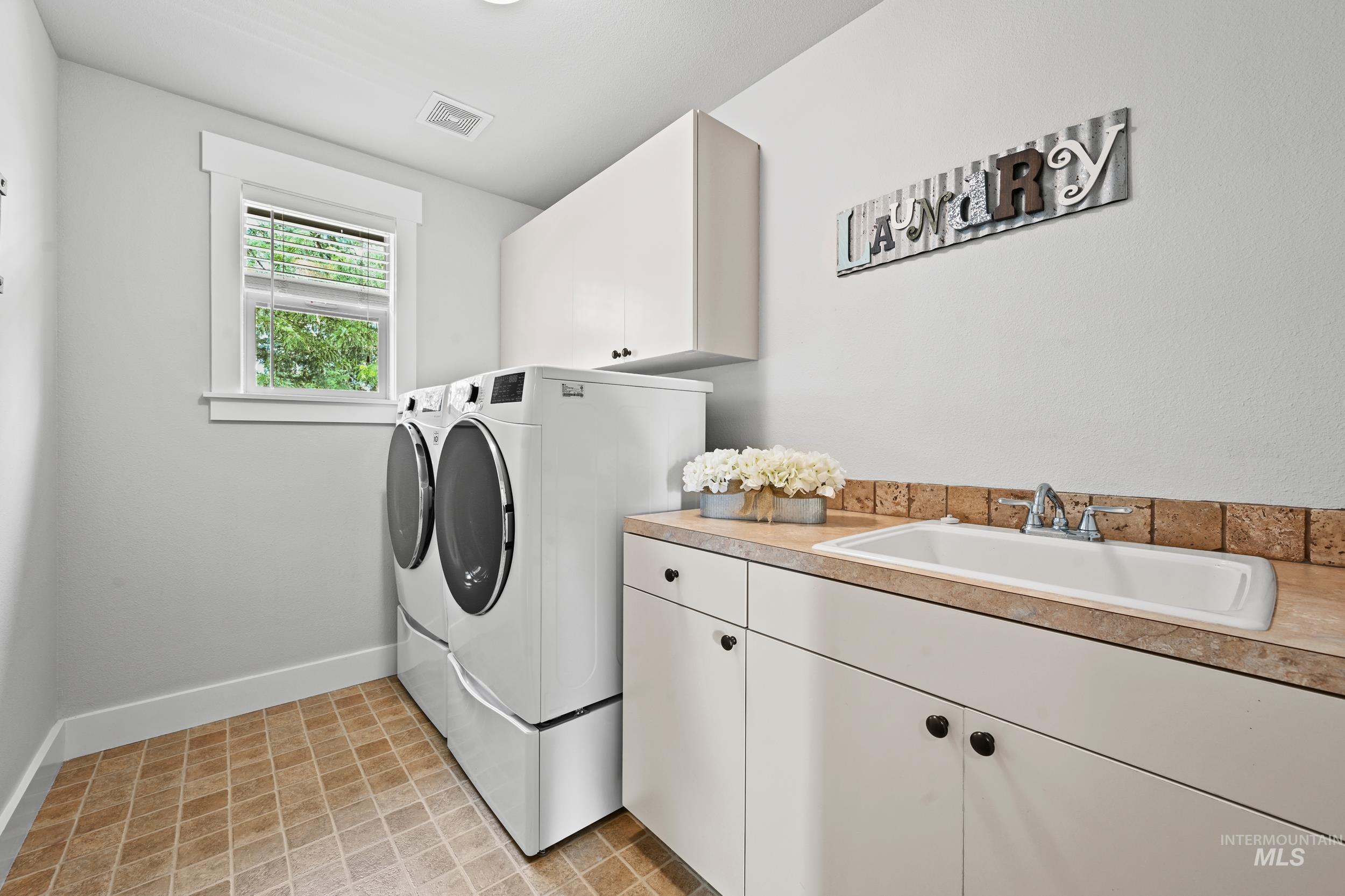 Washroom with washing machine and dryer and cabinet space