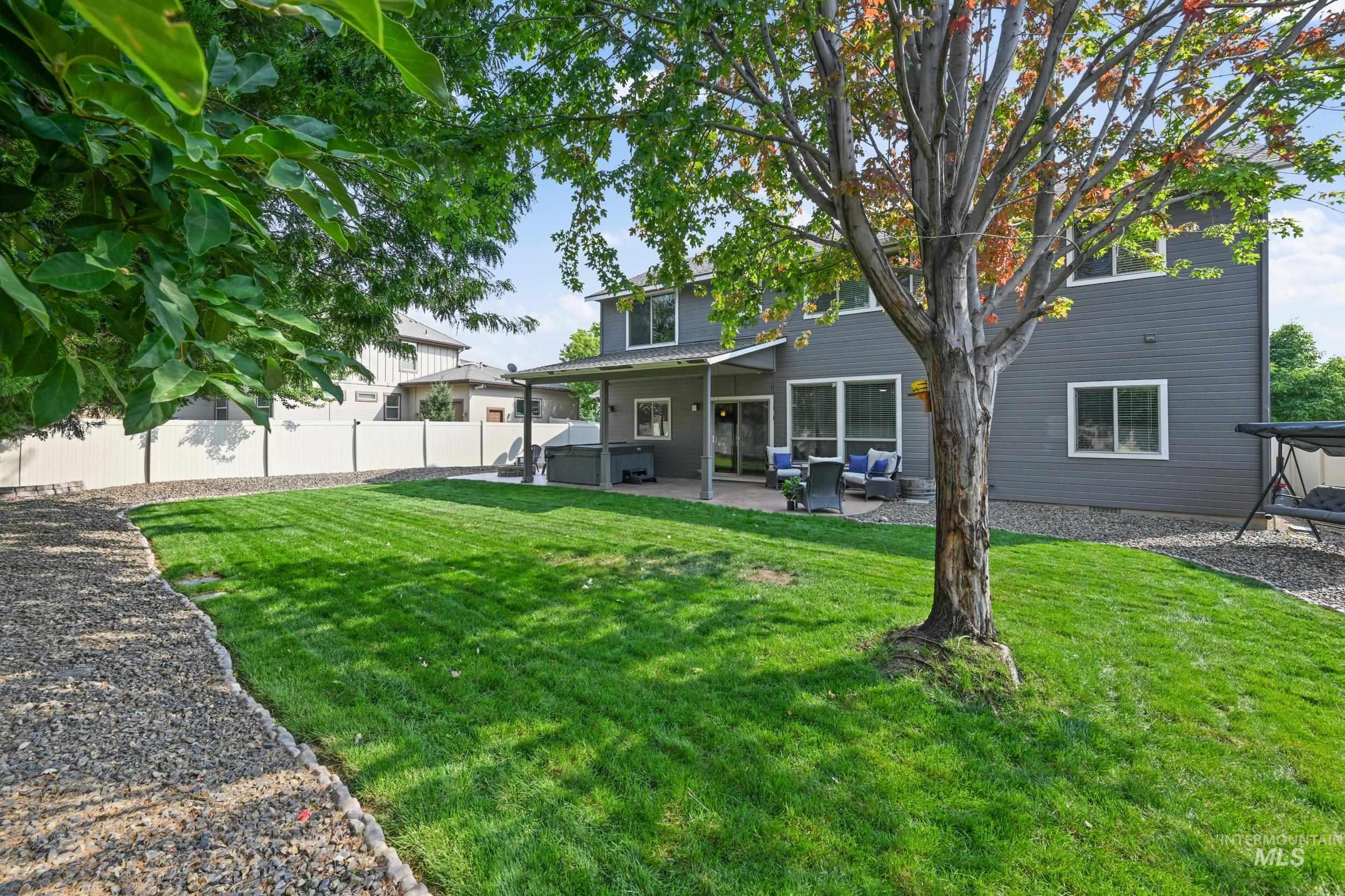 Back of property with a patio, a hot tub, and a fenced backyard