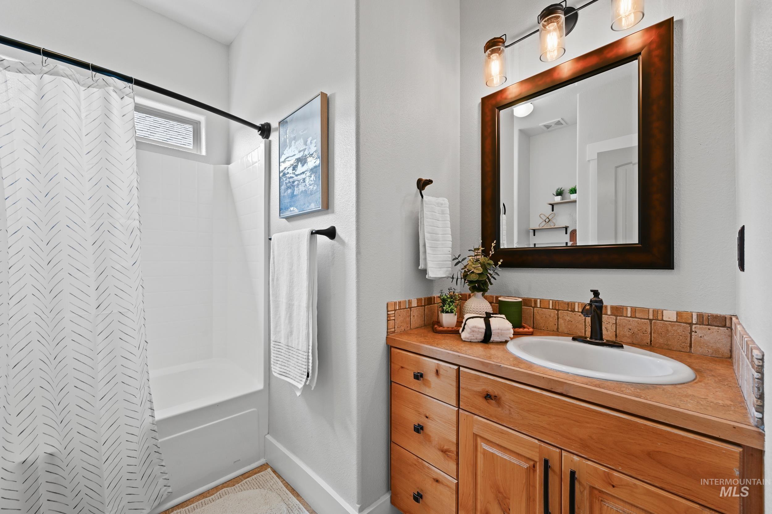 Bathroom with vanity and shower / tub combo with curtain