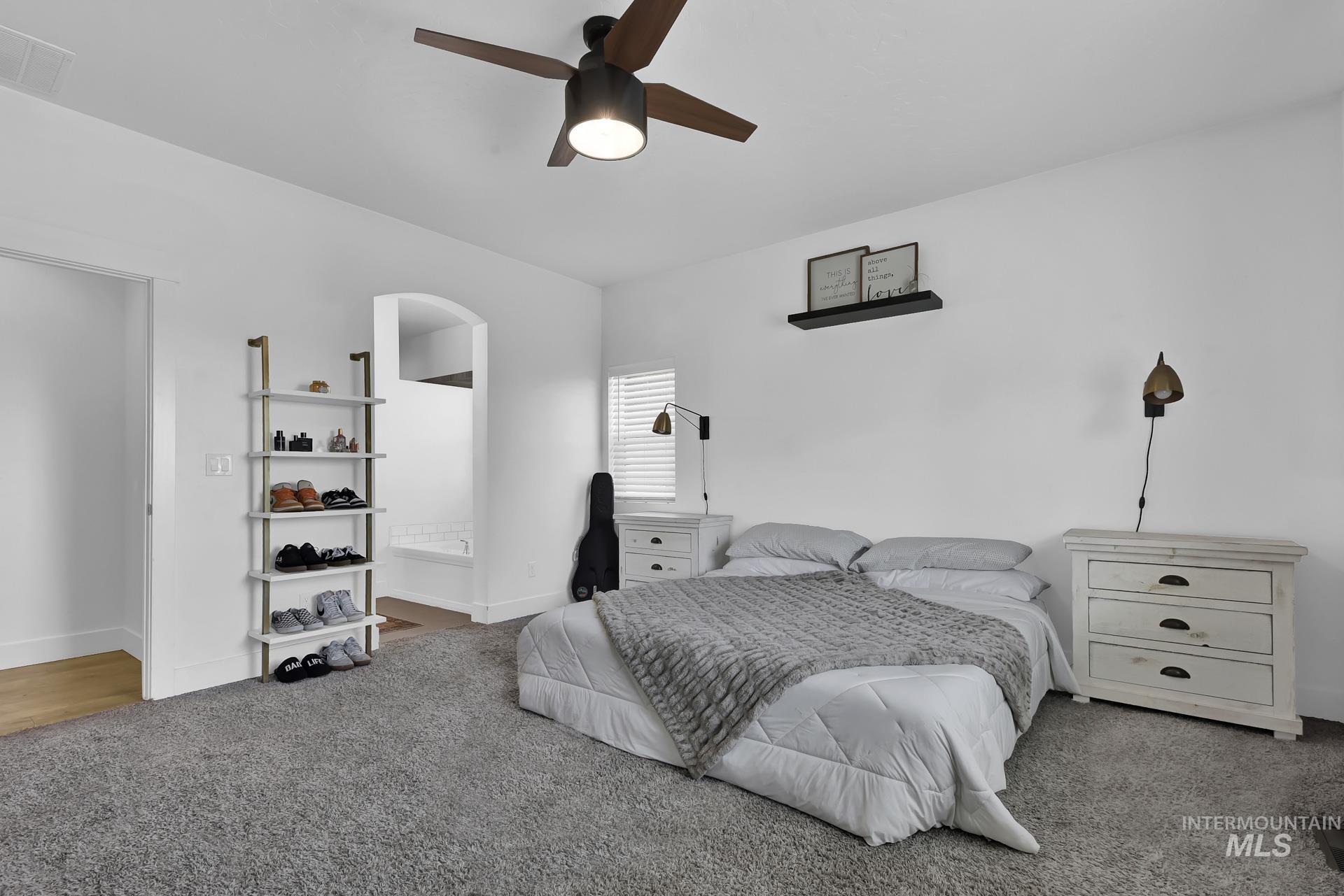 Bedroom featuring ceiling fan, carpet floors, and connected bathroom