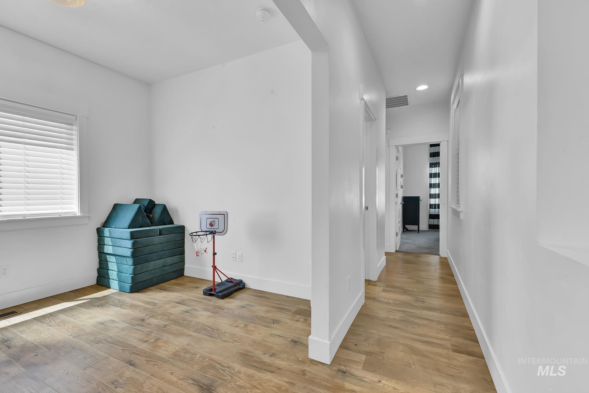Hall with light wood-style flooring and recessed lighting