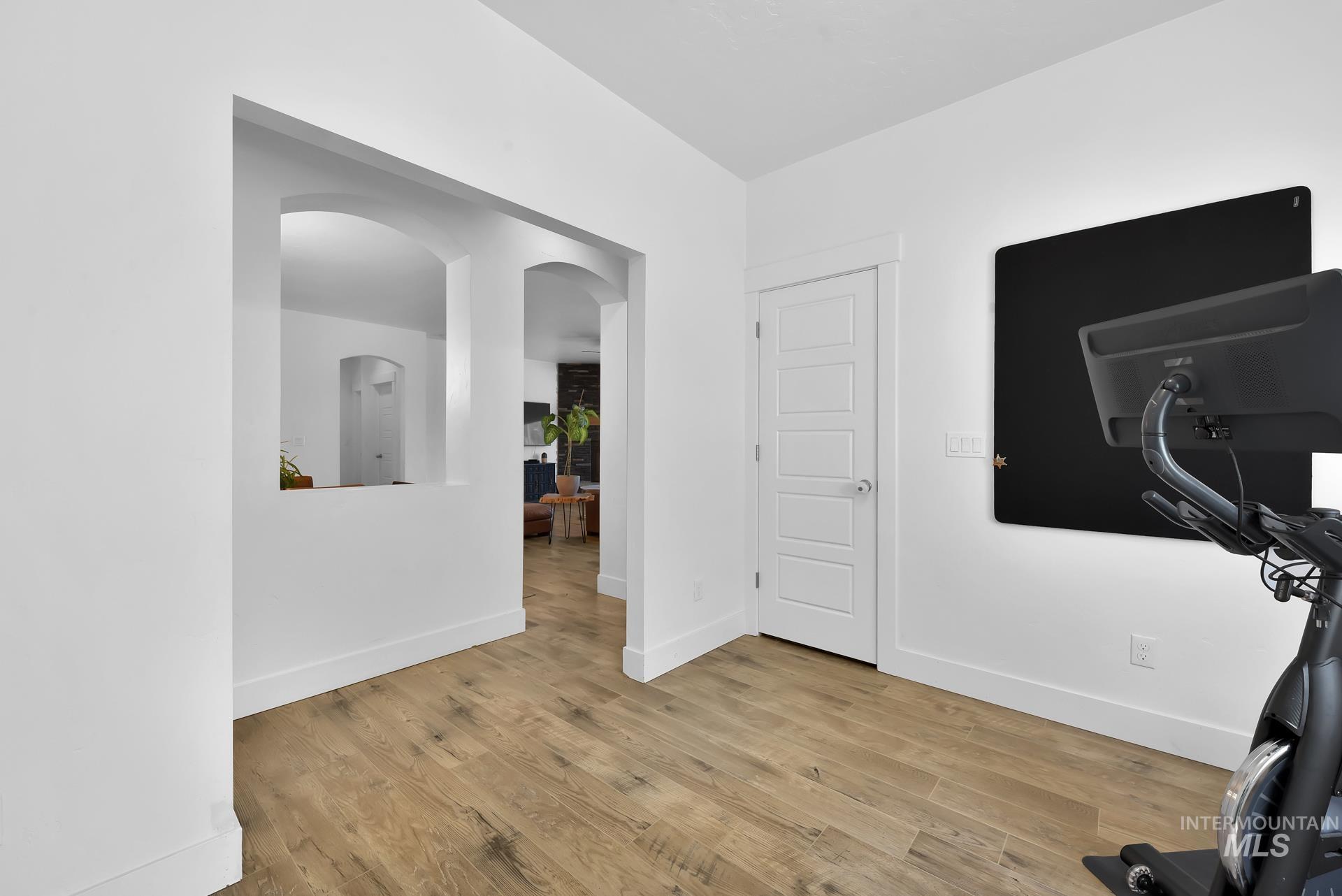 Office area featuring arched walkways and light wood-type flooring