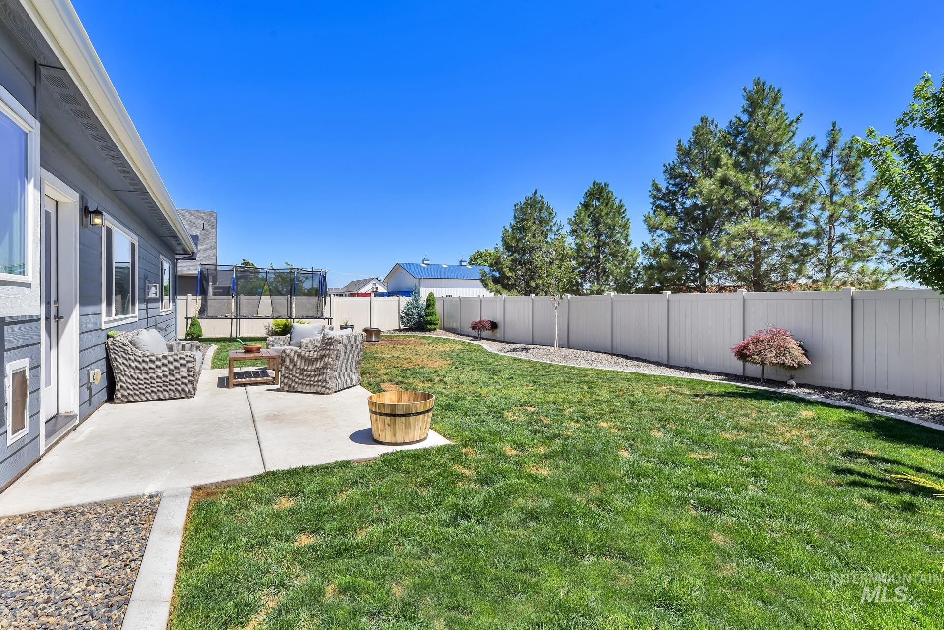 Fenced backyard featuring a patio and an outdoor hangout area