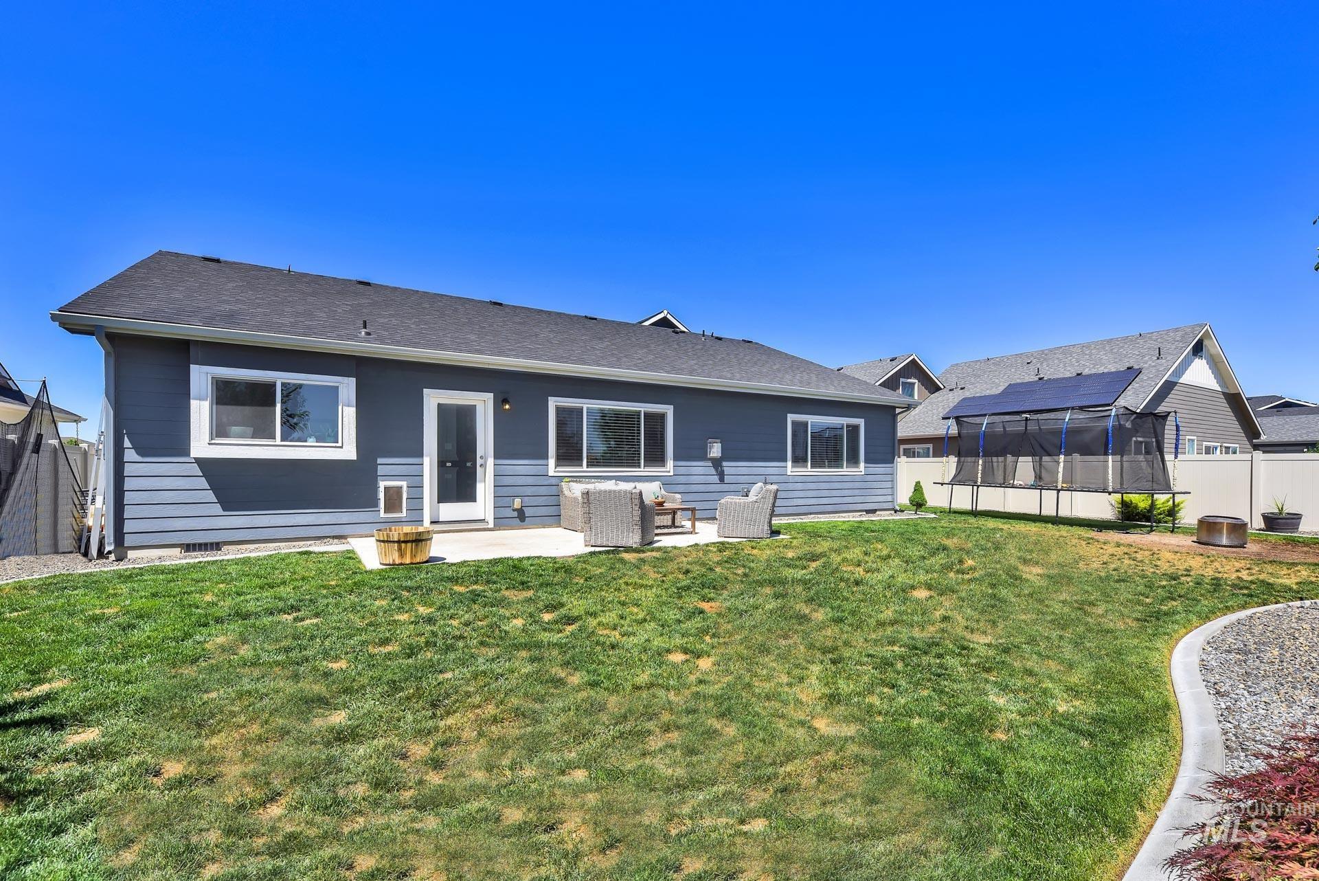 Rear view of property featuring a patio, a fenced backyard, and roof with shingles