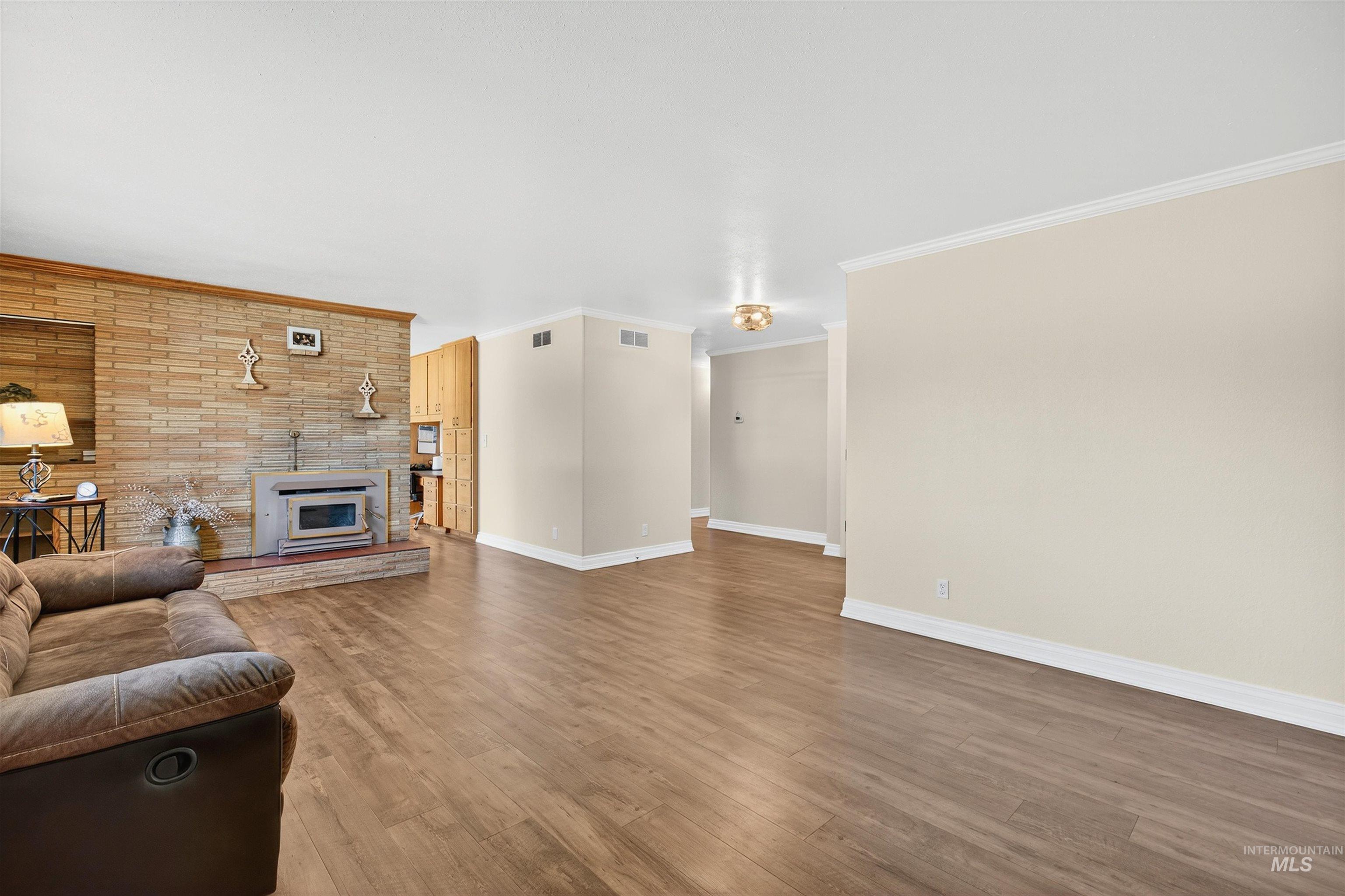 Living area with crown molding and wood finished floors