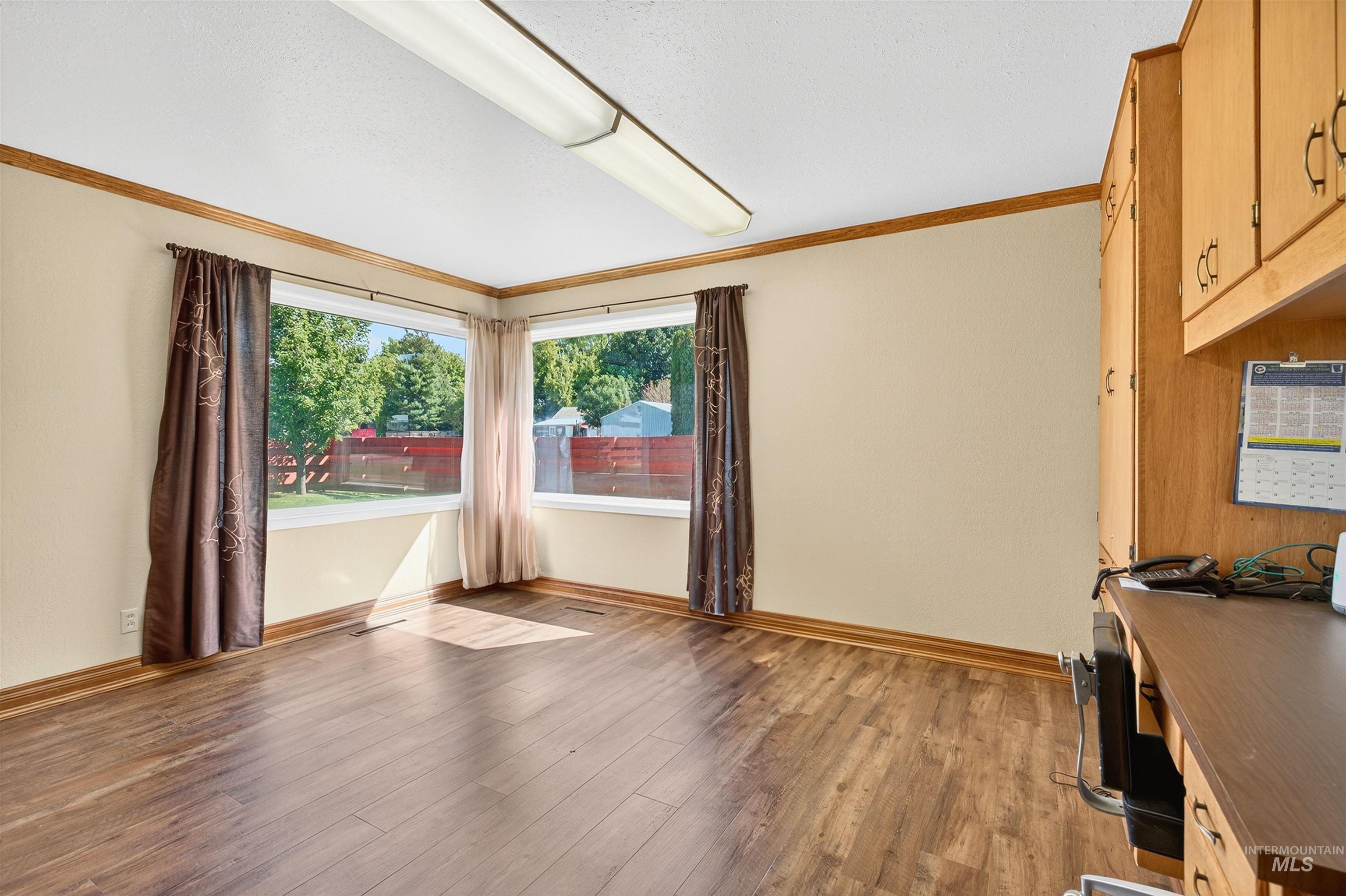 Unfurnished office featuring crown molding and light wood-style flooring
