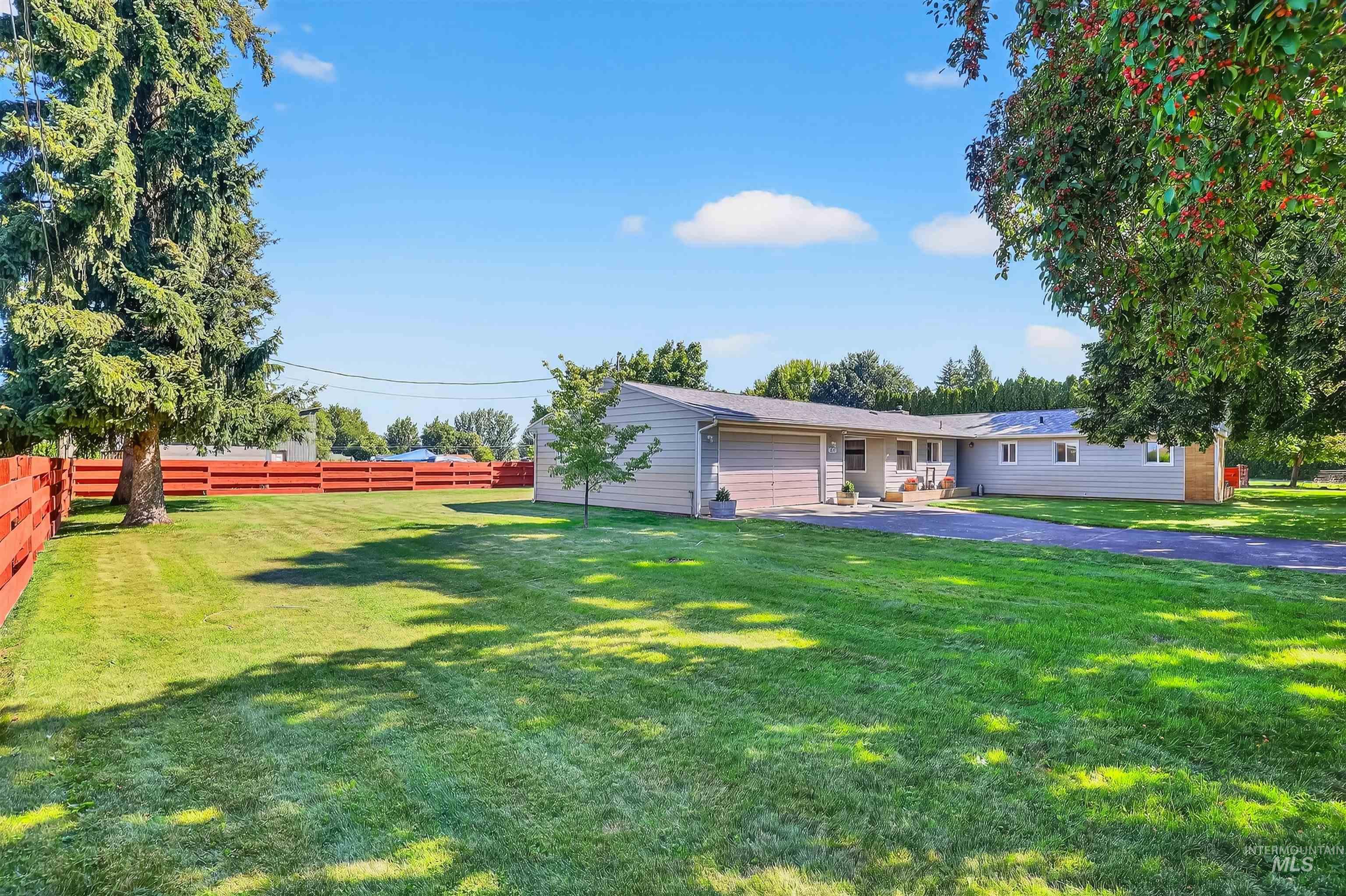 View of front facade with a fenced backyard, a patio area, and a garage