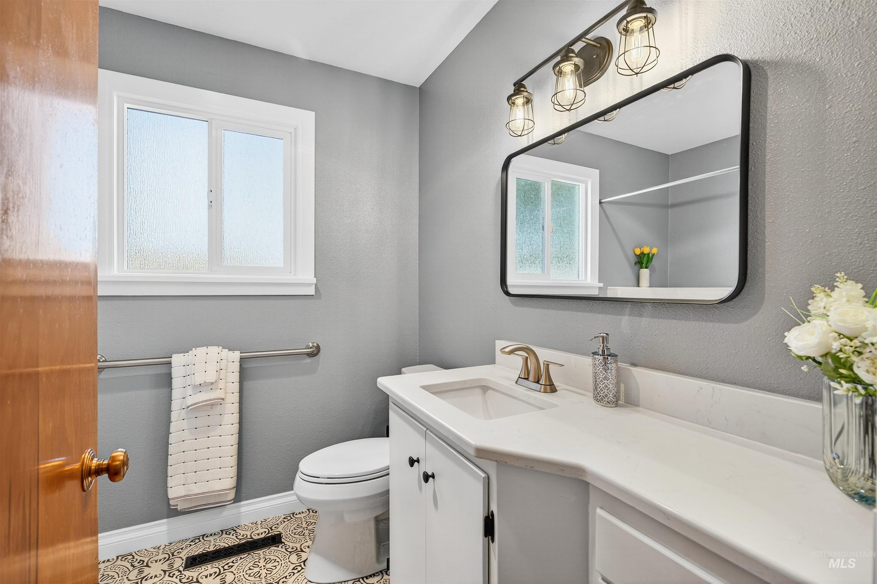 Full bathroom with vanity, a textured wall, and tile patterned flooring