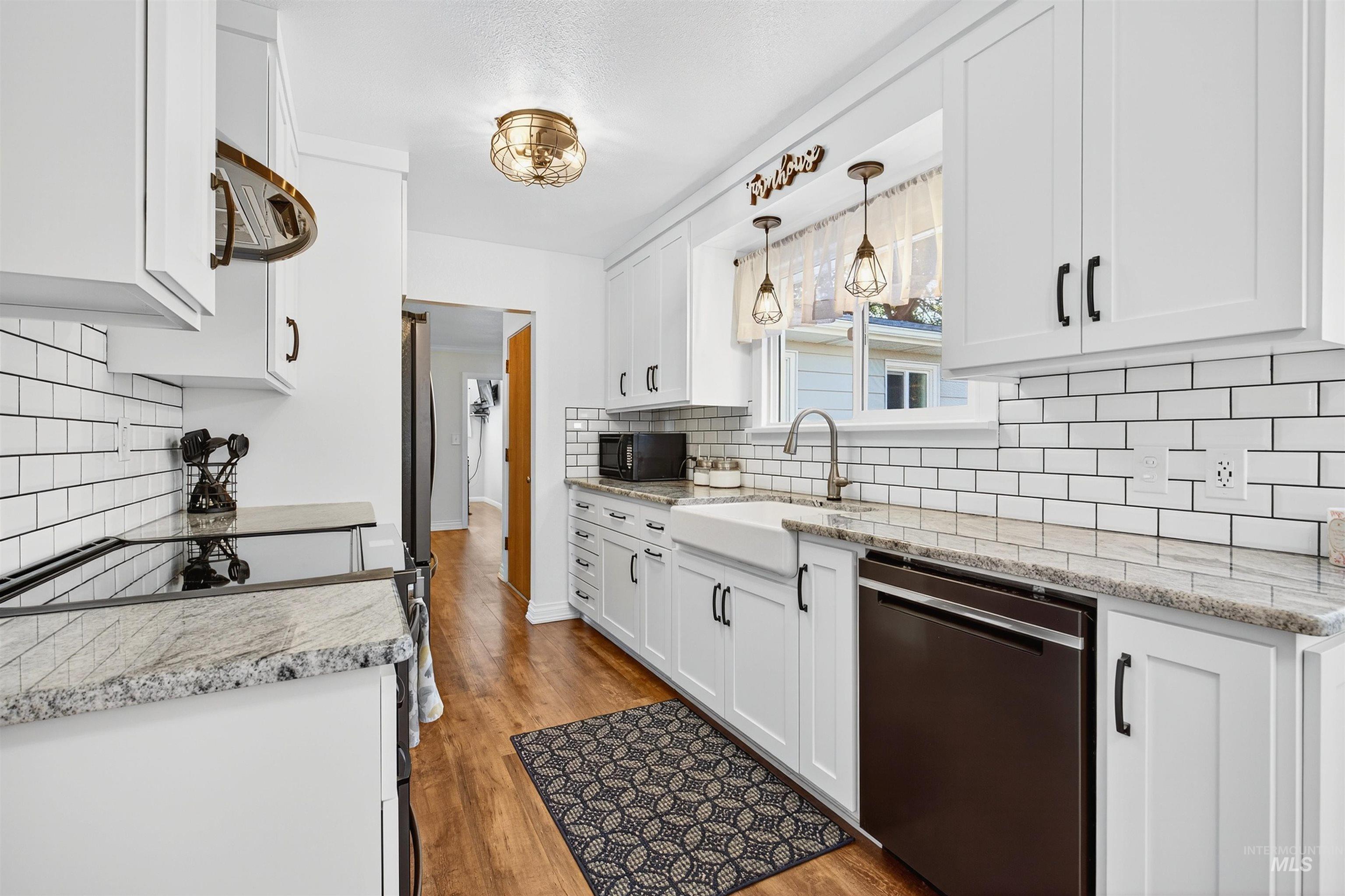 Kitchen with dishwashing machine, white cabinetry, electric range oven, and light wood-style flooring