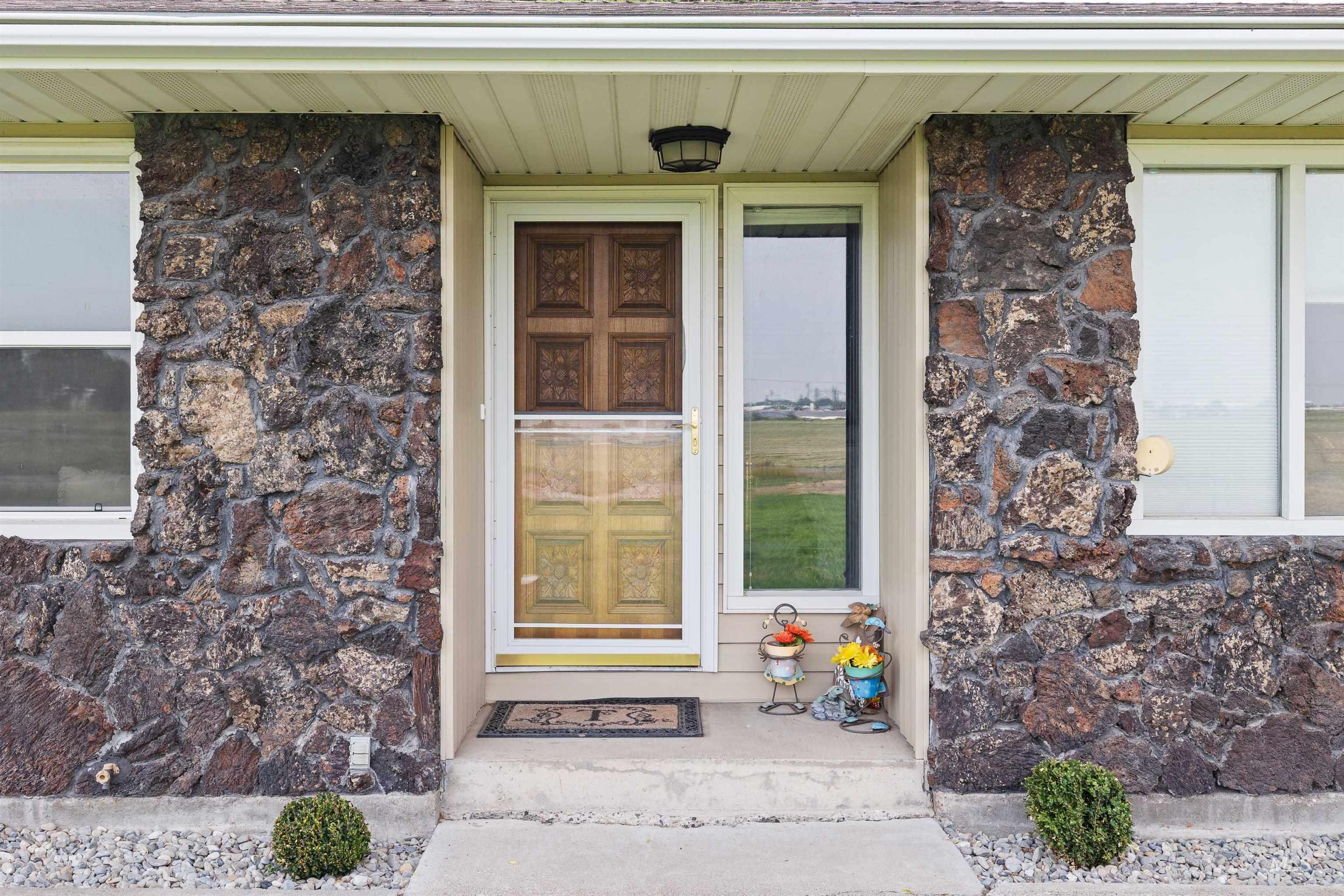 Doorway to property featuring stone siding