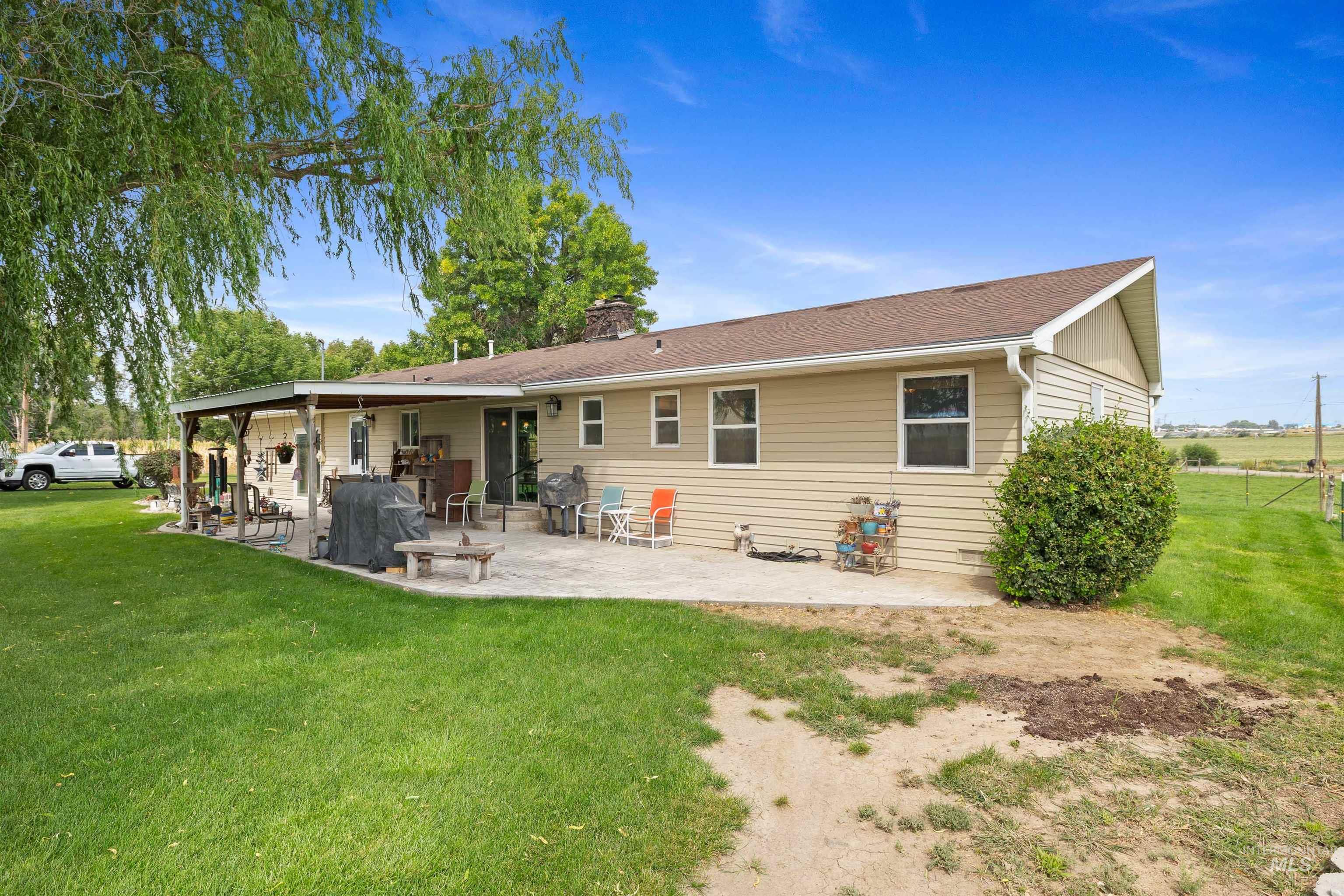 Back of property with a patio area, a lawn, and a chimney
