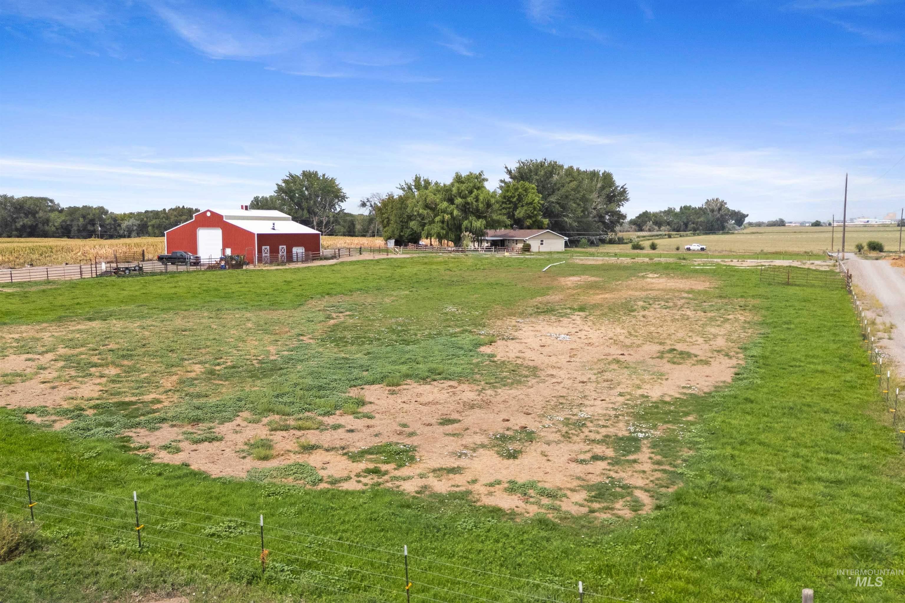 View of yard featuring a view of rural / pastoral area, an outdoor structure, an outbuilding, and a detached garage