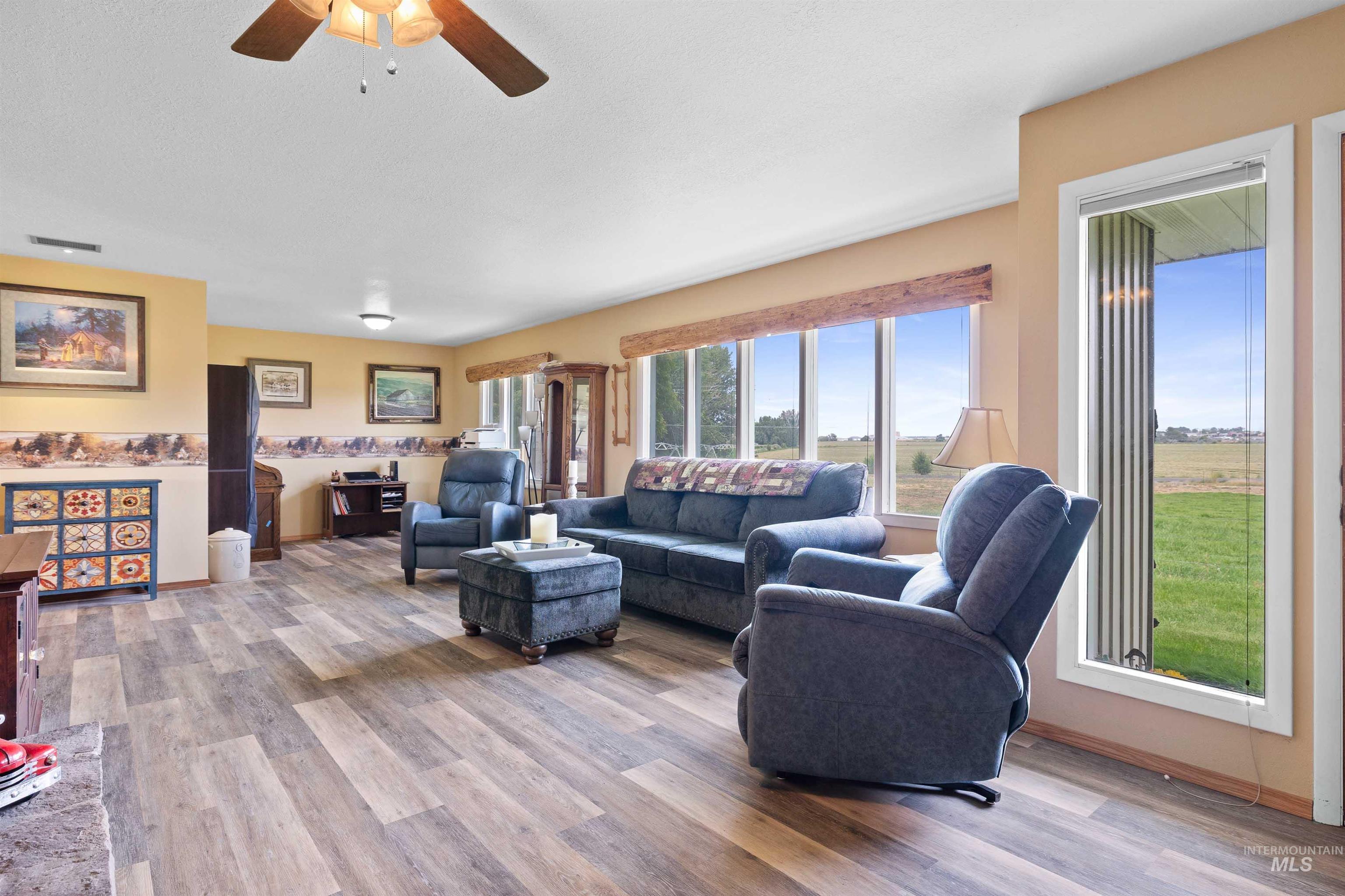 Living room with light wood finished floors and ceiling fan