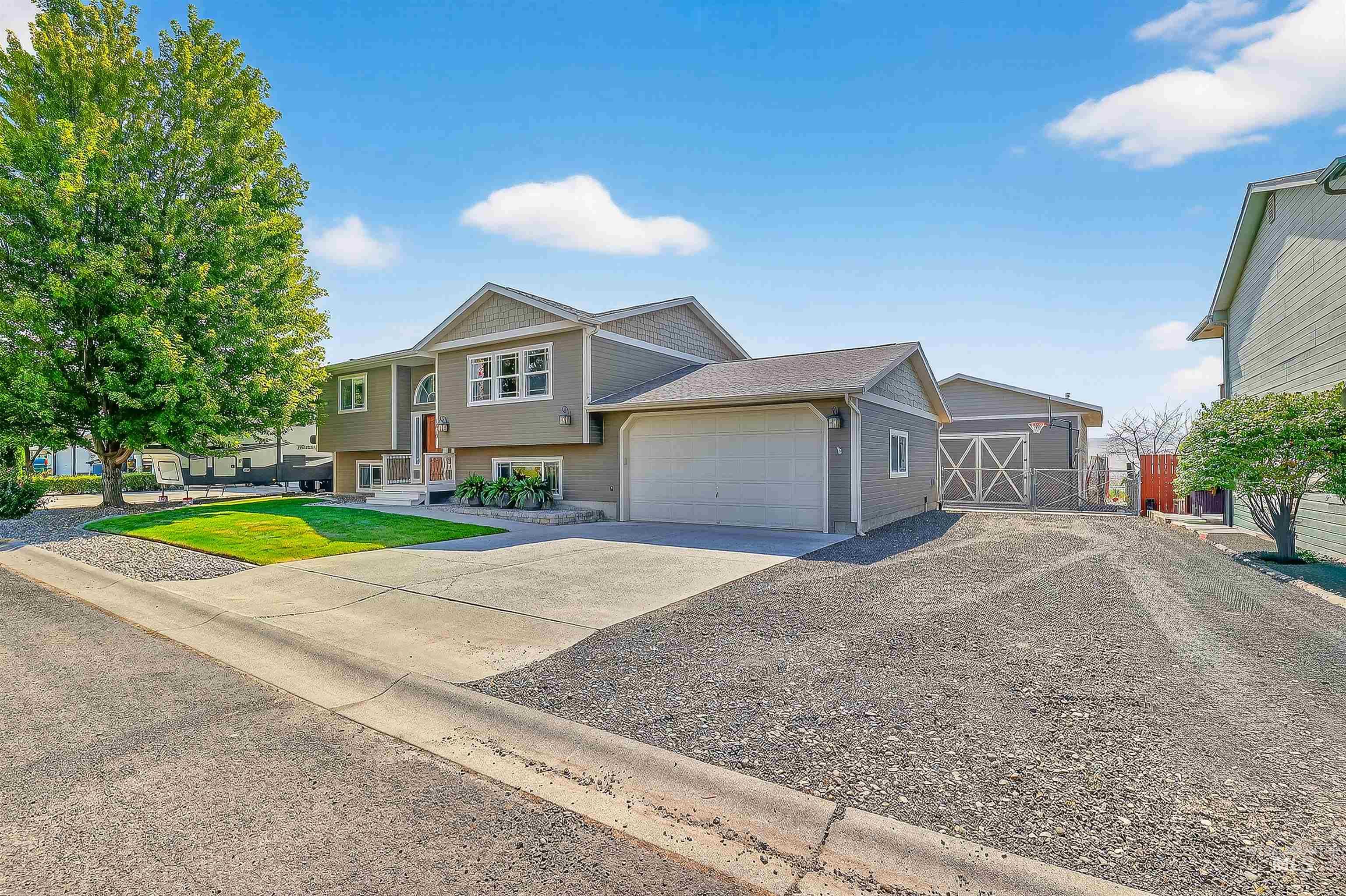 Raised ranch featuring driveway, a garage, and a front yard