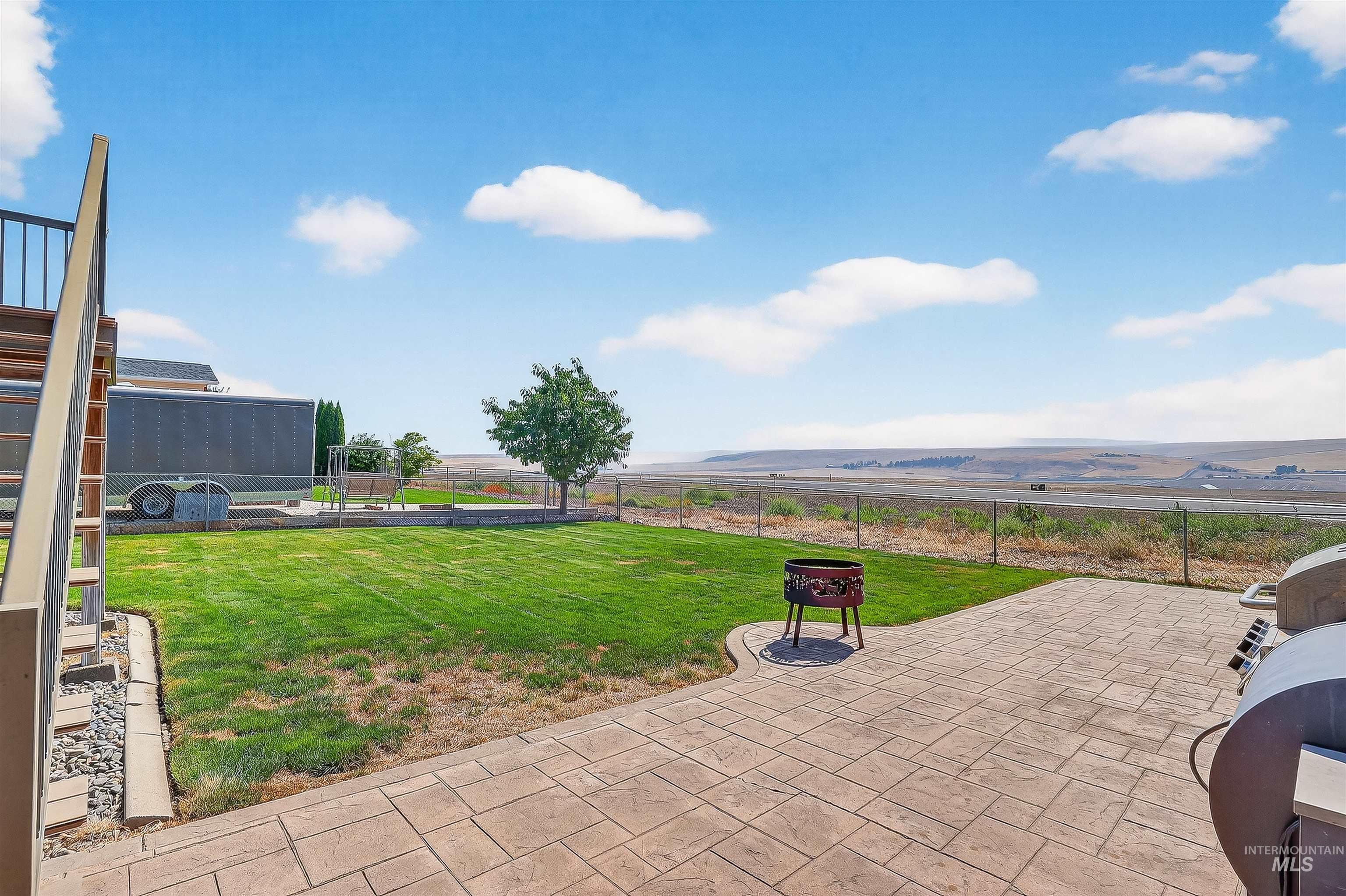 Fenced backyard featuring a patio area and grilling area