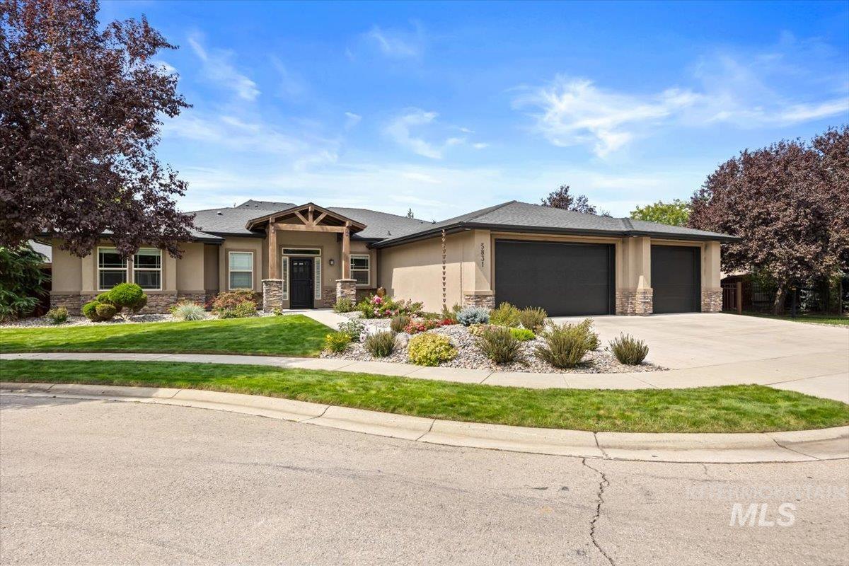 View of front of property featuring stone siding, stucco siding, an attached garage, and concrete driveway