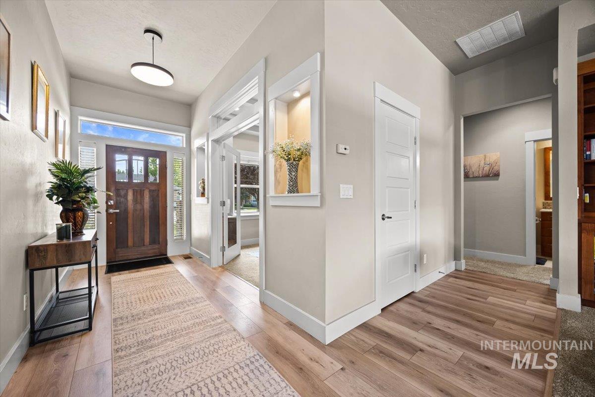 Foyer featuring light wood-type flooring and a textured ceiling