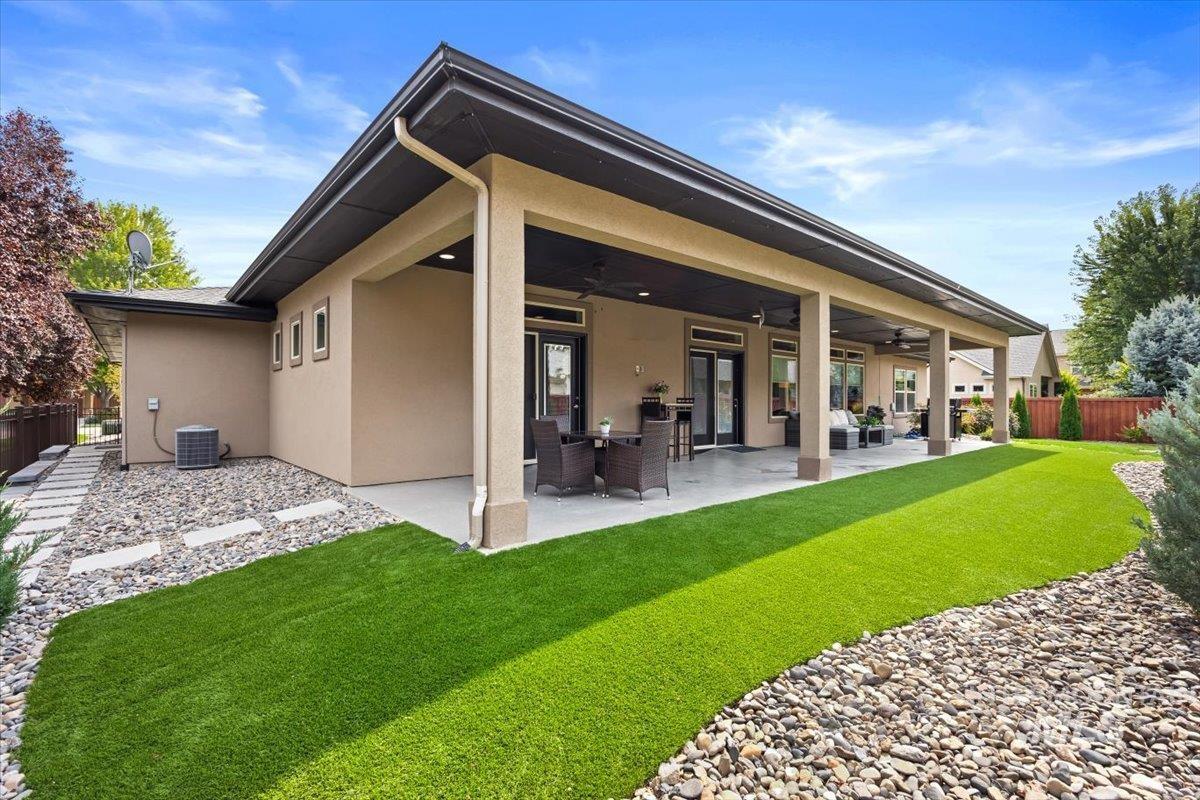 Back of property featuring a fenced backyard, a ceiling fan, a patio, and stucco siding