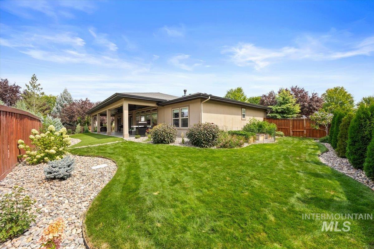 Rear view of property with a fenced backyard, a patio, and stucco siding