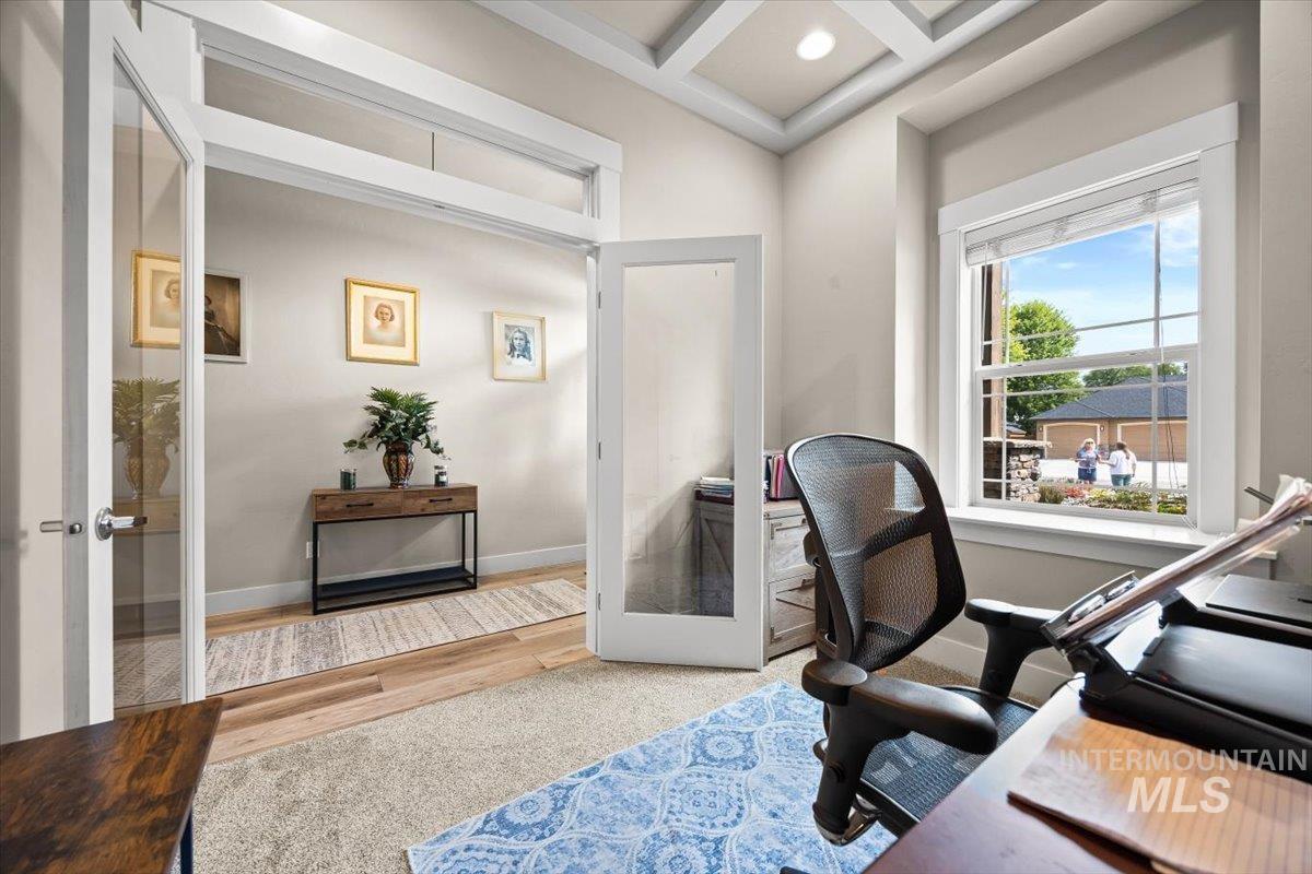 Office area with french doors, coffered ceiling, beamed ceiling, and wood finished floors