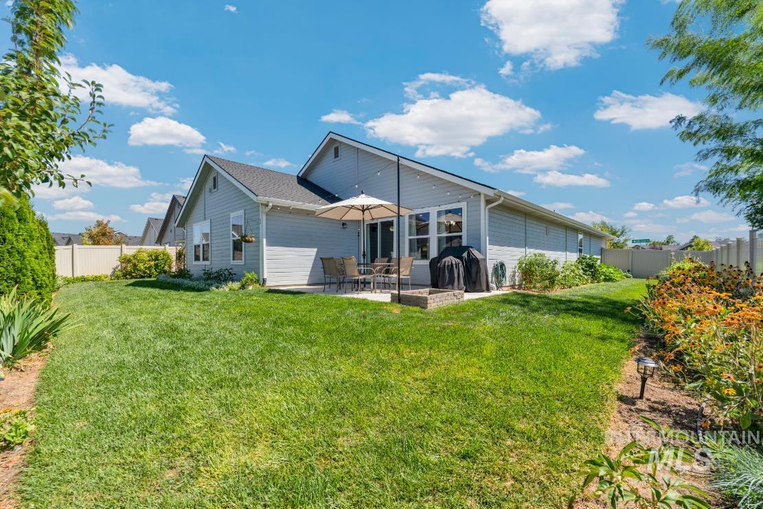 Rear view of property with a fenced backyard and a patio area