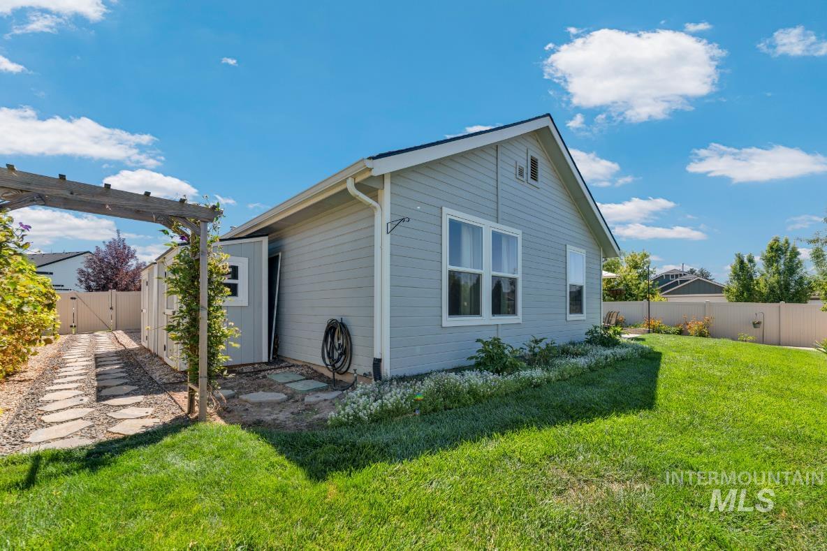 Back of house with a fenced backyard, a patio, and a pergola and fruit trees