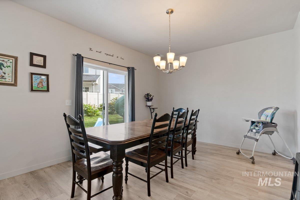 Dining space with light wood-style floors and a chandelier