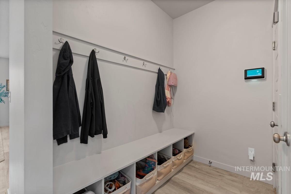 Mudroom with light wood-style floors and baseboards
