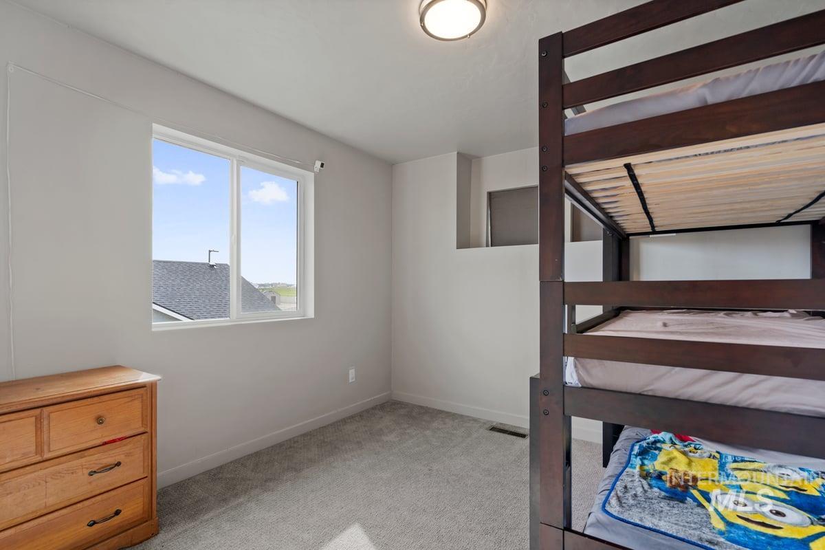 Unfurnished bedroom featuring light carpet and baseboards