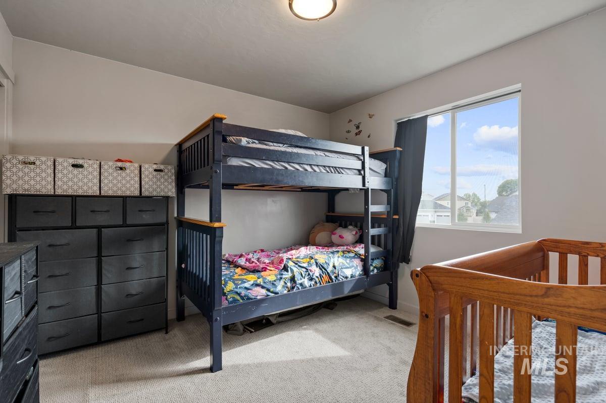 Bedroom featuring light carpet and baseboards