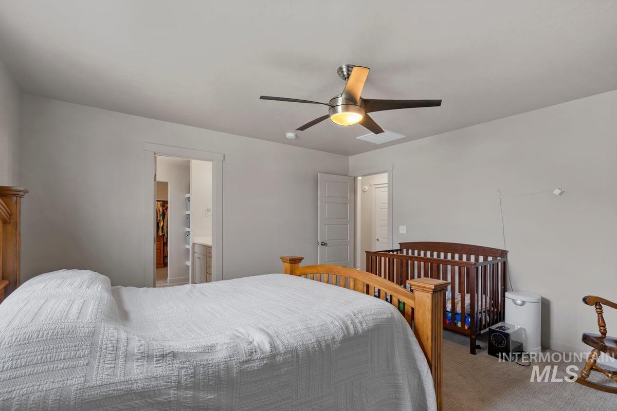 Bedroom with carpet, ceiling fan, and ensuite bath
