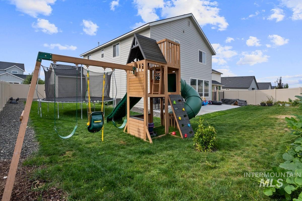 View of jungle gym featuring a fenced backyard and a trampoline