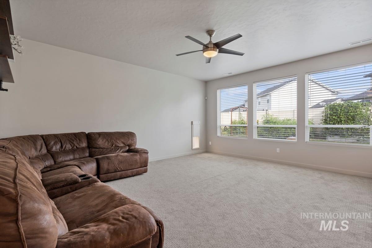 Living area featuring carpet floors and a ceiling fan