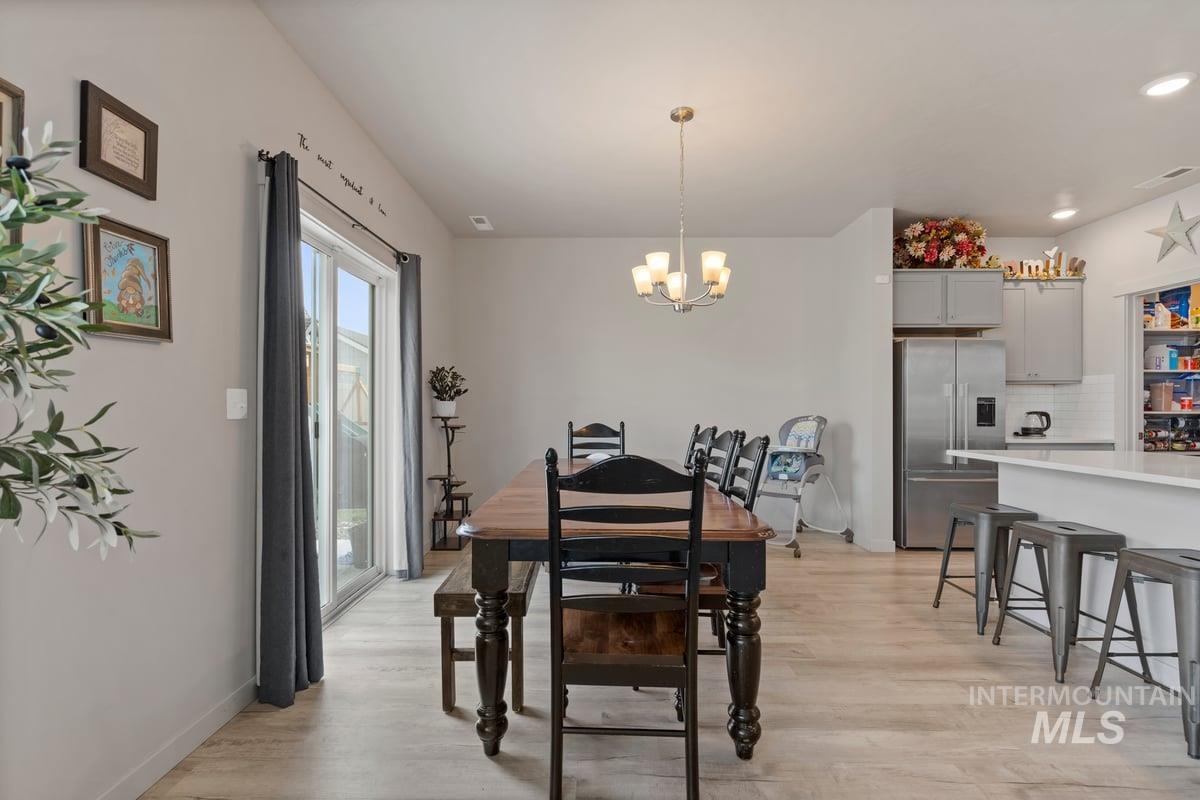 Dining space featuring light wood-style floors, a chandelier, and recessed lighting