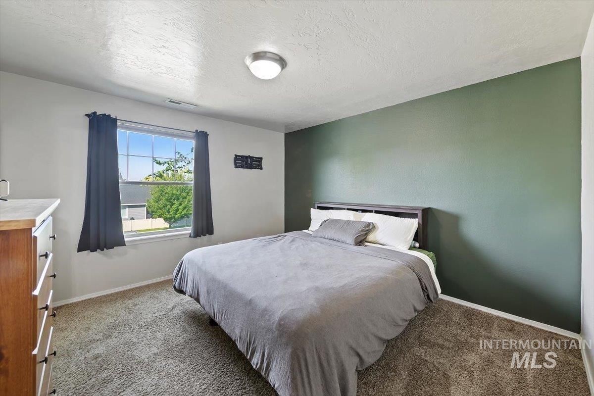Master Bedroom with light carpet and a textured ceiling