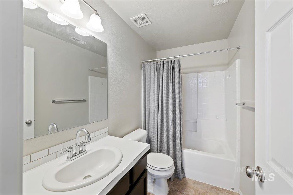 Full bathroom featuring shower / tub combo with curtain and vanity