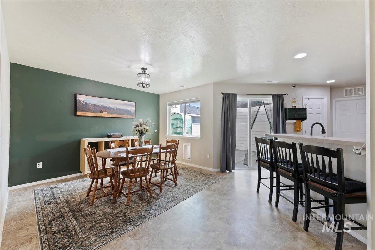 Dining room with a textured ceiling and recessed lighting