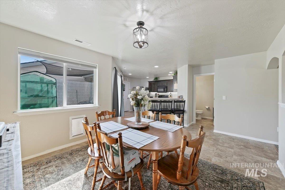 Dining area with a textured ceiling, arched walkways, and recessed lighting