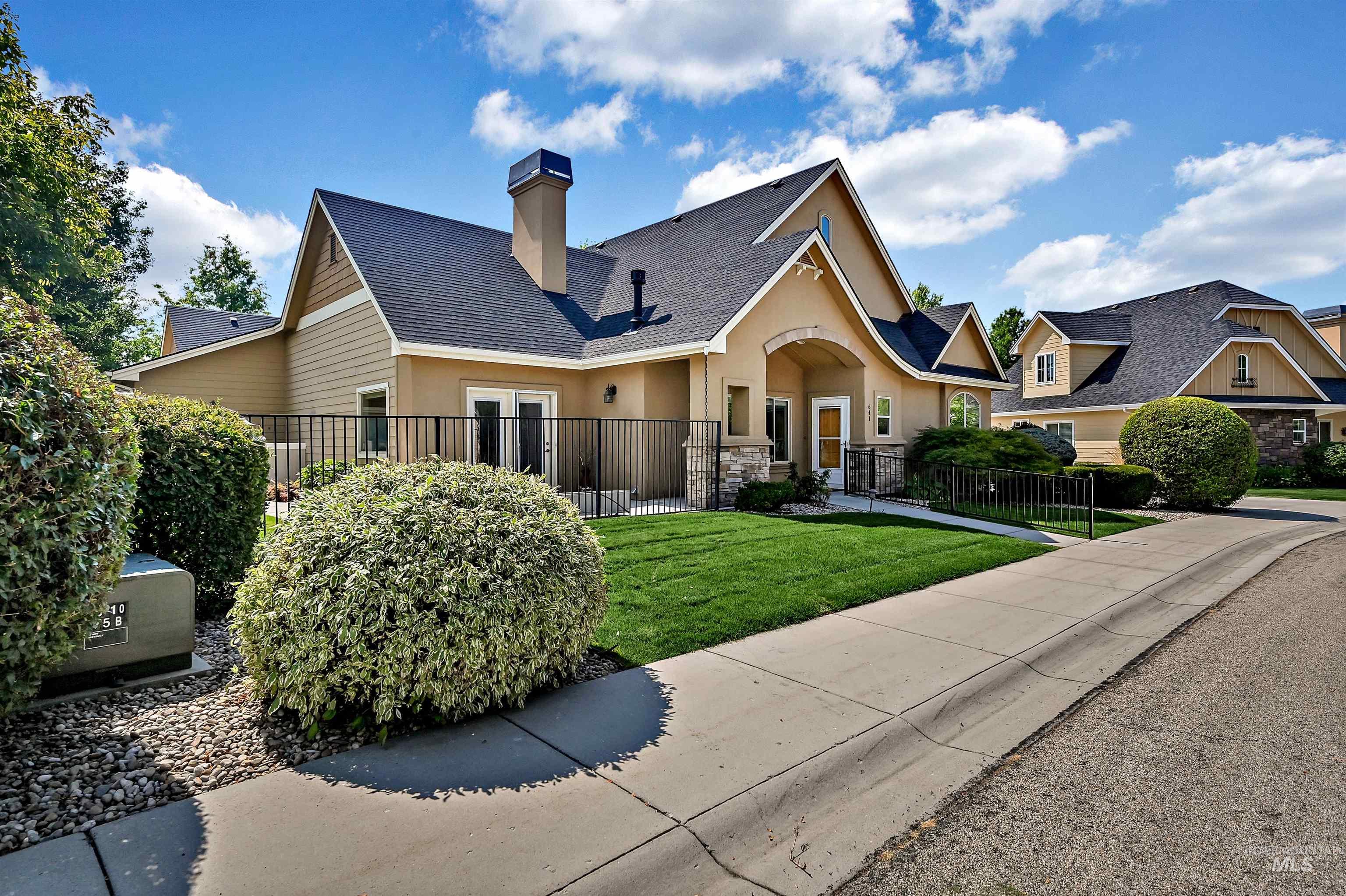 View of front of home with a chimney, stucco siding, and stone siding