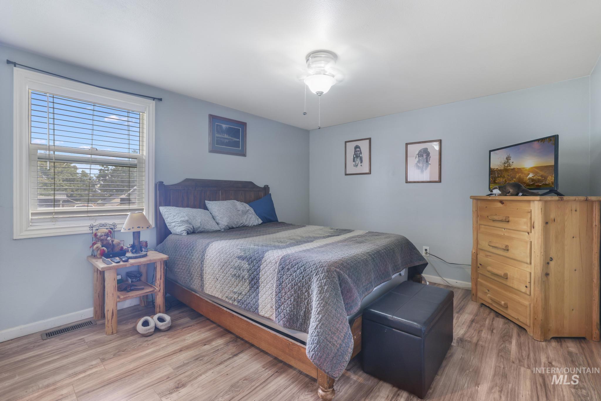 Bedroom with wood finished floors and baseboards