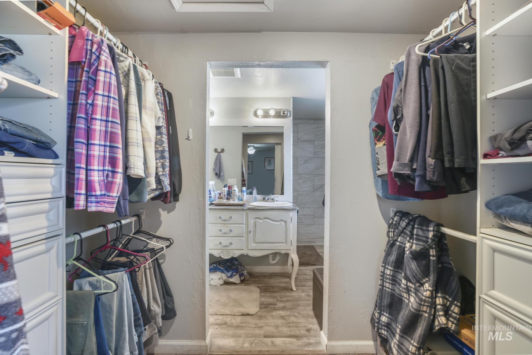 Walk in closet with light wood-style floors and a sink